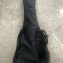 Černý softcase (obal) na kytaru z textilního materiálu. Obal je vybaven rukojetí a zipem. Povrch vykazuje mírné pomačkání látky.