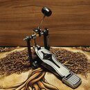 Kovový basový pedál v černé a stříbrné barvě s horní pákou zakončenou černým knoflíkem. Na stříbrném plátku je vyfrézovaný ornament ve tvaru stylizov…