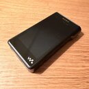 Černý přenosný MP3 přehrávač s displejem. Na horní hraně je bílý nápis SONY a v dolní části logotyp Walkman. Zařízení vykazuje mírné opotřebení povrc…