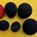 Sada pěti černých a jednoho červeného pěnového filtru na mikrofon v různých velikostech. Jeden červený filtr je zabalen v originálním plastovém obalu…