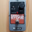 Kytarový efekt v kovovém šedém šasi s černým horním panelem. Na panelu je nápis SMALL STONE a pod ním EH4800 PHASE SHIFTER, ovládací knoflík RATE, př…