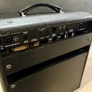 Zadní strana černého kytarového komba s koženým povrchem. Jsou zde viditelné nápisy 230/240 VAC ~ 1.0A SLU BLU, Hi Voltage Fuse, 50/60 Hz 280 WATTS a…