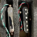 Dvě kytarové snímače umístěné v černé pěnové výplni. Levý snímač má chromovaný kryt s nápisy NOISELESS a Fender. Pravý snímač je černý, má šest vidit…