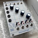 Bílý modul s modrými nápisy a čárkami, který obsahuje čtyři modré otočné knoflíky, čtyři červené LED diody a čtyři malé přepínače. V horní části je n…