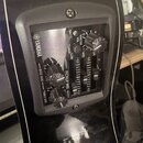 Detail ovládacího panelu akustické kytary značky YAMAHA. Panel obsahuje dva otočné knoflíky s nápisy BASS SIDE a TREBLE SIDE, jeden hlavní ovratkový…