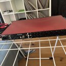 Červený rackový audio interface značky Focusrite. Na předním panelu jsou viditelné nápisy Focusrite, Optical a 8 kombinovaných vstupů označených jako…