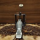 Kovový pedál basového bubnu s nápravou a beizerem. Pedál má stříbrnou barvu, v horní části je umístěn bílý plišový beater. Na komponentech nejsou vid…