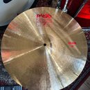Zlatý kovový činel s viditelným broušením. Na povrchu je červený nápis PAiste 2002 a TRADE MARK MADE IN SWITZERLAND. V pravé části je červený nápis C…