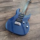 Modrá elektrická kytara s dvojstupňovitým tělem a hnědým hmatníkem. Nástroj je vybaven dvěma černými humbuckery, stahovacím mechanismem a dvěma ovlád…