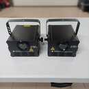 Dvě černé laserové světla v hranatých kovových skříních s úchytkymi rukojitmi. Na přední straně každého zařízení je nápis „vollights Laser RGB 1W“ a…