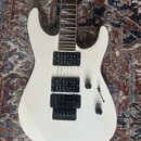 Bílá elektrická kytara s tmavým hnedým hmatníkem. Nástroj má tři černé humbuckery, dva ovládací knofíky a jeden přepínač. Na středním snímači je vidi…