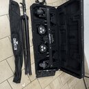 Černý kufr s pěnovou výplní obsahuje čtyři světla uspořádaná v řadě na držáku s nápisem GoBAR MOVE. Vedle kufrů je černý rozkládací stativ a černá př…