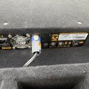 Zadní panel černého elektronického zařízení s ventilátorem a napájecím konektorem. Na panelu jsou nápisy SPEAKER OUT, LINE OUT a značka CE. Štítek ob…