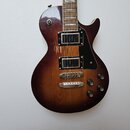 Elektrická kytara s tmele hnědým povrchem v přechodu (sunburst) a dvěma humbuckery. Na těle jsou viditelné oděrky a opotřebení laku, zejména v oblast…