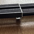 Černý pedál s protiskluzovou povrchovou úpravou v horní části. Na levé straně je bílý nápis D'Addario. Nástroj stojí na čtyřech kovových nožkách s gu…
