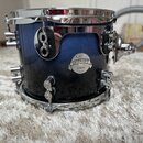 Modrý buben s kovovými obručmi a ladicími šrouby. Na korpusu je nalepený oválný štítek s nápisy „Carl Palmer“, „PLATINUM SERIES“ a „All-Maple Shell“.…