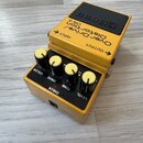 Žlutý kytarový efekt s černým horním panelem, na kterém je nápis BOSS. Na těle jsou texty OverDrive/ Distortion OS-2 a označení vstupů INPUT a OUTPUT…