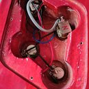 Fotografie zachycuje vyfrézovanou dutinu v červeném lakovaném těle kytary. Uvnitř jsou vidět tři potenciometry a elektroinstalace s červenými, modrým…