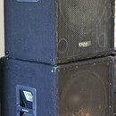 Dvě černé reproduktorové bedny s kovovou mřížkou v přední části, naskládané na sebe. Horní bedna má v pravém dolním rohu mřížky bílý nápis ibiza. Pov…