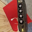Černý rackový přístroj s kovovým šasi. Na zadní straně jsou čtyři chladicí ventilátory s nápisem SUNON a dvě konektory XLR. V horní části je umístěn…