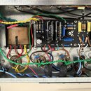 Fotografie zachycuje vnitřek elektronického zařízení s viditelným zapojením komponentů. Jsou zde vidět transformátor, kondenzátory s nápisy 35uF 500V…