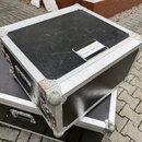 Černý transportní kufr s hliníkovými hranami a kovovými rohy. Na horní straně je nalepený bílý štítek s nápisem Rozvodele 400V/63A-230V. Povrch kufrů…