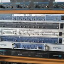 Sestup rackového vybavení v dřevěném stojanu. Jsou zde vidět zařízení s nápisy NUENDO 8 I/O (steinberg), tři jednotky RME Analog / Digital Interface…