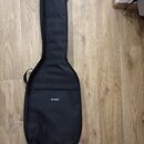 Černý textilní pouzdro (gig bag) na kytaru. Na přední straně je bílý nápis th·mann. Povrch látky vykazuje drobné světlé nečistoty a opotřebení.