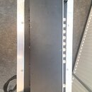 Černý obdélníkový elektronický přístroj umístěný v hliníkovém transportním kufru. Na levé straně přístroje je vidět chladicí žebrování a v dolní část…