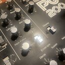 Detailní pohled na ovládací panel syntetizátoru s nápisem Roland PG 200. Jsou vidět různé stříbrné otočné knoflíky a přepínače s popisky jako VCA, LF…