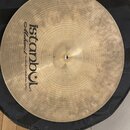Kruhová činely z mosazi v přirozené zlatavé barvě s viditelným broušením. Na povrchu je černý nápis „istanbul Mehmet Handmade Cymbals from Turkey“. V…