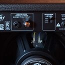 Zadní strana kytarového komba s černým povrchem. Je zde nápis Peavey BANDIT 112 a logo s textem STANDARD TUBE. Panel obsahuje ovládací prvky SPEAKER…