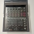 Černý mixovací pult značky RELOOP s označením JMH-40 DSP umístěný v přepravním kufru. Zařízení obsahuje čtyři kanály s rovnovážnými posuvníky, knoflí…