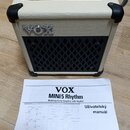 Kremový kytarový kombo zesilovač s černou mřížkou reproduktoru a nápisem VOX na přední straně. Na horním ovládacím panelu jsou různé přepínače a pote…
