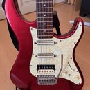 červeně lakovaná elektrická kytara s bílým perleťovým pickguardem. Kytara má tři snímače (dva jednoduché a jeden humbucker u kobylku) a třetí knofík.…