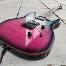 Elektrická kytara s tělem v purpurovo-černém gradientu a viditelnou strukturou dřeva. Nástroj má dva humbuckery, tři černé ovládací knofíky a jeden p…