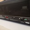 Zadní strana kytarového komba s černou perforovanou mřížkou a modrým potahem. Na spodním panelu je logo Marshall, přepínač OUTPUT SELECTION a nápisy…