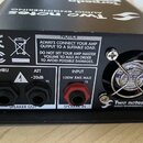Zadní strana černého elektronického zařízení značky Two notes AUDIO ENGINEERING. Jsou zde vidět konektory SPEAKER OUT (označení THRU a ATT -20dB) a S…