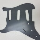 Šedý plastový pickguard pro elektrickou kytaru s třemi výřezy pro snímače. Povrch je hladký a matný, bez viditelných značek, log nebo nápisů. V mater…