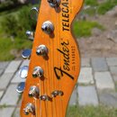 Fotografie zachycuje hlavu kytary v přirozené dřevěné barvě s nápisy Fender® TELECASTER a MADE IN USA. Je zde viditelné sériové číslo SERIAL NUMBER S…