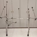 Chromovaná kovová konstrukce stojanu pro bicí nástroje s několika rameny a úchopy. Stojan je vybaven černými plastovými knoflíky a koncovkami. Na pov…
