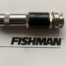 Kabel s kovovým konektorem a černým plastovým prstencem uprostřed. Pod konektorem je na bílém podkladu černý nápis FISHMAN®. Povrch kovových částí vy…