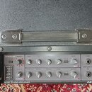 Kytarový zesilovač s černým texturovaným povrchem a plastovou rukojetí. Na ovládacím panelu je nápis GUITAR AMPLIFIER G-I0R a sekce EMODE DSP EFFECTS…