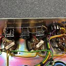 Fotografie zachycuje vnitřek kovového šasi s elektronickými komponenty a kabeláží. Jsou zde vidět tři přepínače s nápisem CLIFF, několik potenciometr…
