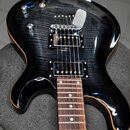 Černá elektrická kytara s prosvítající strukturou dřeva na těle. Na hradle je vyryt nápis "Gibson". Nástroj má dva humbuckery, dvě otočné potenciomet…