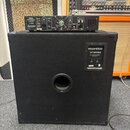Zadní strana černé basové reprobedny s nápisem Hartke VK-series, pod kterým je uvedeno VENTO BASS CABINET 400 WATTS. Na bedně je umístěn černý zesilo…