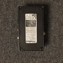 Fotografie zachycuje spodní stranu černého efektpedálu značky Digitech. Na spodku je umístěná bílá nálepka s technickými informacemi, varovnými texty…