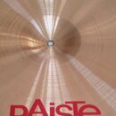 Zlatavý kovový činel s koncentrickým broušením povrchu. V dolní části je červený nápis pAiste a pod ním menší text MADE IN SWITZERLAND. Povrch je čis…