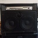 Černý basový kombo zesilovač s dvěma reproduktory za kovovou mřížkou. Na ovládacím panelu je nápis BACKLINE 210 a logo GK, dále text 500 WATT BASS AM…