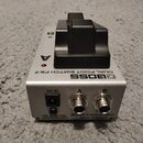 Stříbrný dvoupedálový spínací jednotka s černými plasty. Na horní straně je nápis DUAL FOOT SWITCH FS-7 a logo BOSS, na zadní straně jsou dva konekto…